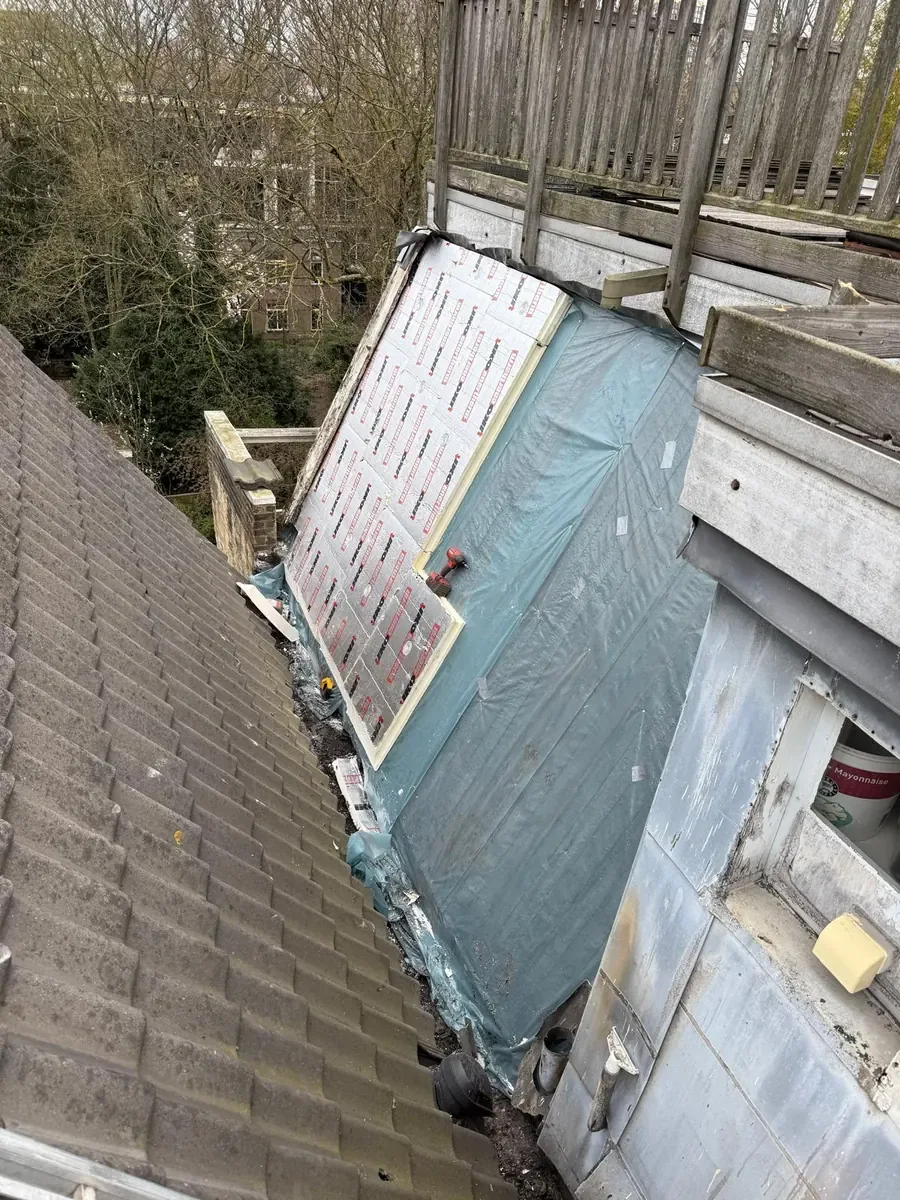 Isolatieplaten en folie op het dakvlak onder de houten terrasrand