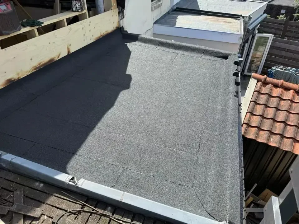 Overzicht van een plat dak met bitumen en afgewerkte dakranden